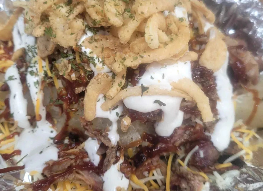Loaded Brisket spud with BBQ sauce, ranch, and crispy fried onions