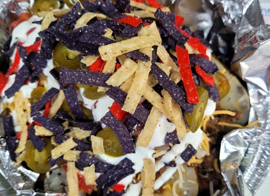 Taco Tato spud with seasoned ground beef, salsa, sour cream, jalapeños, and tortilla strips