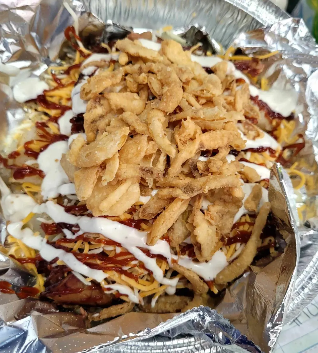 Loaded Brisket spud from the Busted Spud food truck in Appleton, WI — piled with BBQ brisket, cheese, ranch, and crispy fried onions