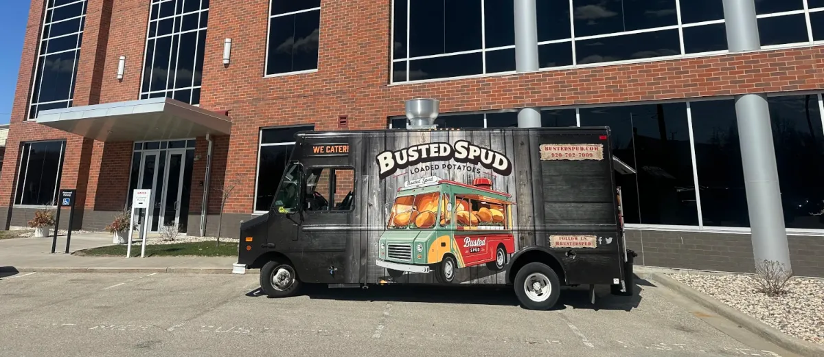 Side of the Busted Spud food truck showing the vintage truck wrap, parked in Appleton, Wisconsin